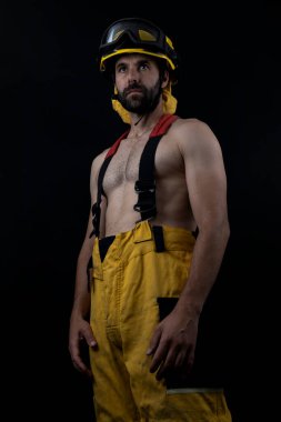 Fotoğraf stüdyosunda poz veren üstsüz itfaiyeci.