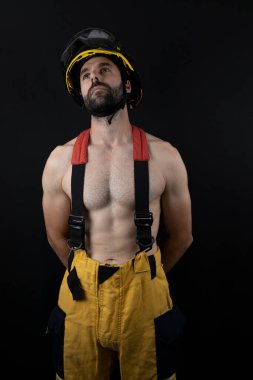 Fotoğraf stüdyosunda poz veren üstsüz itfaiyeci.