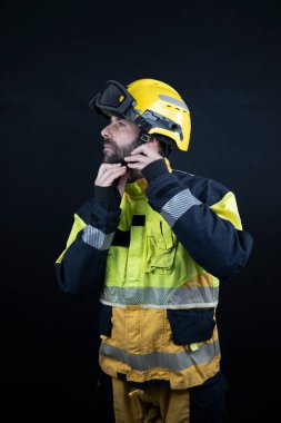 Üniformalı itfaiyeci kaskını bir fotoğraf stüdyosuna takıyor.