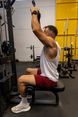 Spor salonunda egzersiz yapan güçlü bir adam.