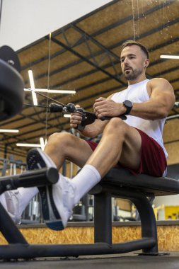 Spor salonunda sırtını çalıştıran bir adam.