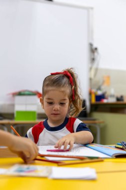 Okulda resim yapan küçük bir kız..
