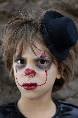 Cadılar Bayramı için korkunç bir palyaço gibi giyinmiş bir çocuğun portresi..