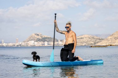 Adam köpekle sörf yapıyor..