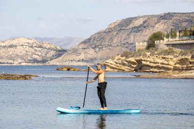 Tişörtsüz, dövmeli, dalgıç kıyafeti giyen adam..