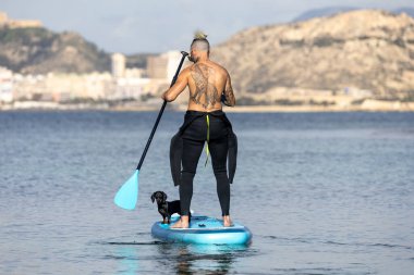 Adam köpekle sörf yapıyor..