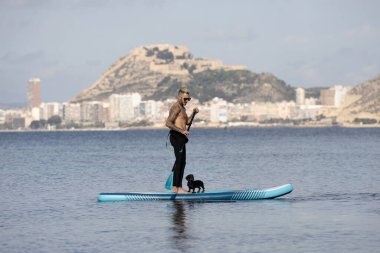 Adam köpekle sörf yapıyor..