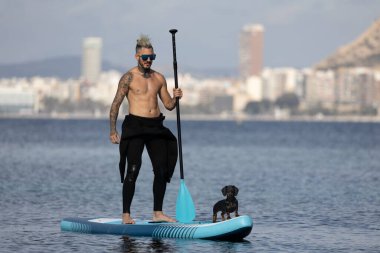 Adam köpekle sörf yapıyor..