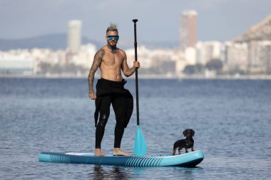 Adam köpekle sörf yapıyor..