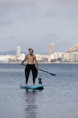 Adam köpekle sörf yapıyor..