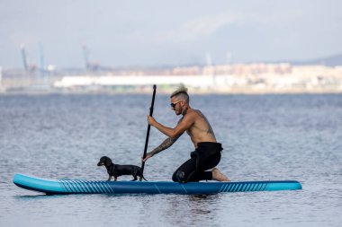Adam köpekle sörf yapıyor..