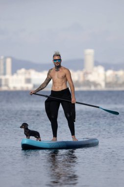 Adam köpekle sörf yapıyor..