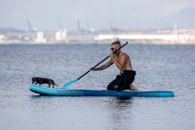 Adam köpekle sörf yapıyor..