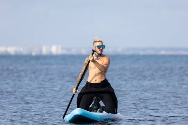 Adam köpekle sörf yapıyor..