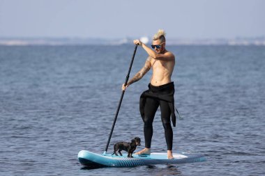 Adam köpekle sörf yapıyor..