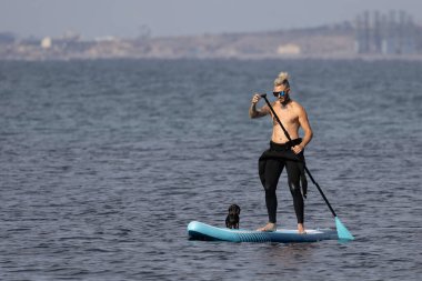 Adam köpekle sörf yapıyor..