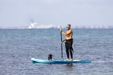 Adam köpekle sörf yapıyor..