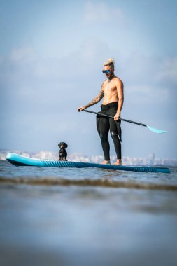 Adam köpekle sörf yapıyor..