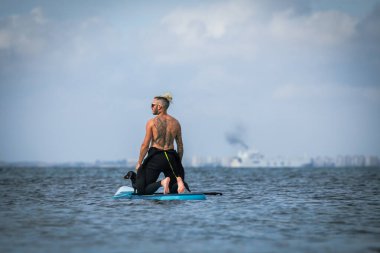 Adam köpekle sörf yapıyor..