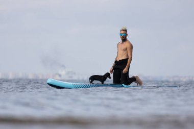 Adam köpekle sörf yapıyor..