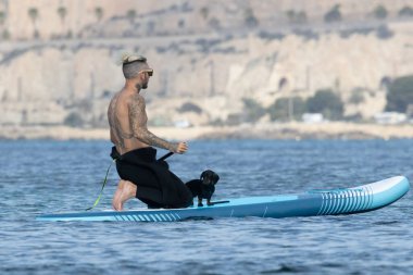 Adam köpekle sörf yapıyor..