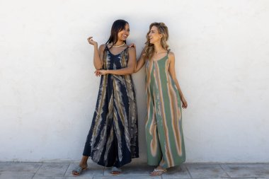 Beyaz duvarda poz veren sarışın ve esmer mankenler..