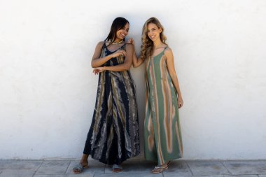 Beyaz duvarda poz veren sarışın ve esmer mankenler..