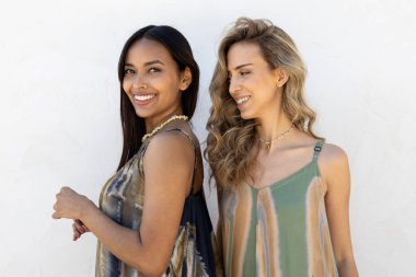 Beyaz duvarda poz veren sarışın ve esmer mankenler..