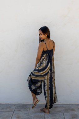 Beyaz bir duvarda yaz kıyafetleri içinde poz veren mankenler..