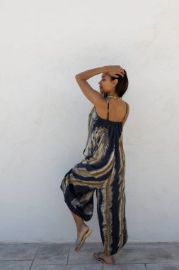 Beyaz bir duvarda yaz kıyafetleri içinde poz veren mankenler..