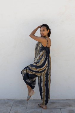 Beyaz bir duvarda yaz kıyafetleri içinde poz veren mankenler..