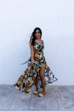 Beyaz arka planda esmer bir kadın. Yazlık elbise giyiyor..