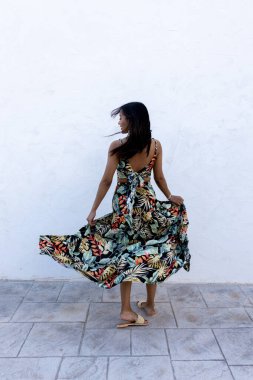 Beyaz arka planda esmer bir kadın. Yazlık elbise giyiyor..