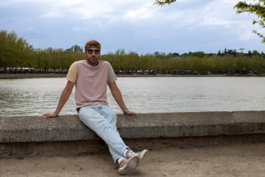 Gölde oturan erkek model..