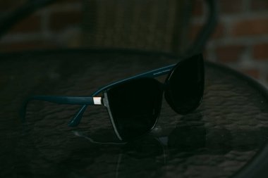 sunglasses with green frame on a glass table