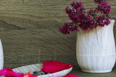 pembe gül yapraklı bir sabun kabı, ahşap arka planda diş fırçası için mor leylak kabı. Yararlı hijyen ürünleri ve kişisel bakım. Mesaj veya logo için yer