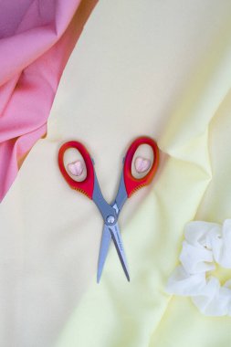 Kırmızı kumaş dikmek için makaslı kumaş.