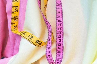 Pembe arka planda şerit ve mezura ölçümü