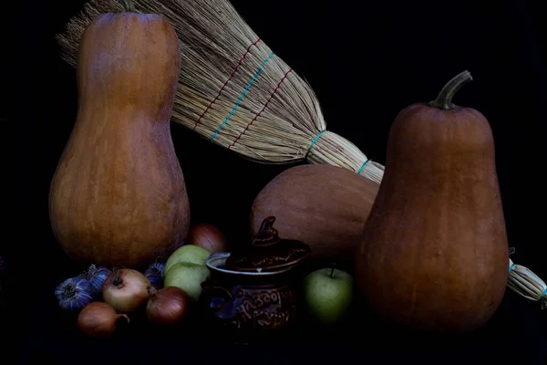 still life with fruits and vegetables, broom on black background. autumn still life. autumn season concept
