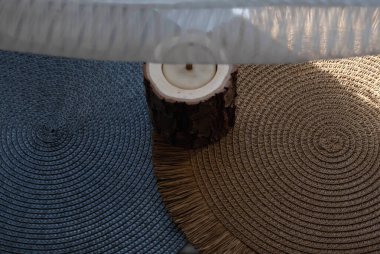 Gri ve kahverengi halı üzerinde bir ahşap mum, beyaz tül