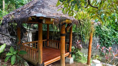 Sazdan çatılı geleneksel bambu kulübesi, kapalı bir açık hava oturma ve yeme alanı olarak kullanılıyor..