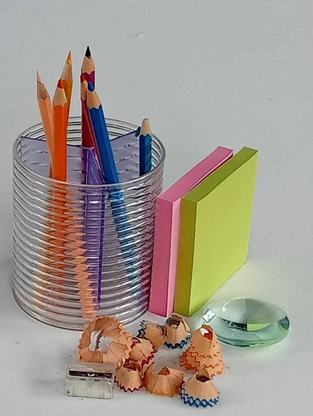 Pencil case, colored pencils and glass paperweight.