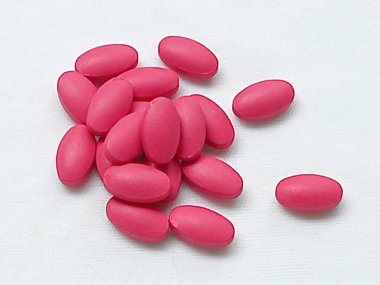 Beyaz arka planda kırmızı haplar yerleştirilmiş ShoTLIST sağlık oval şekli. Sağlık ekiplerinin yakın çekim görüntüleri.