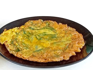 SHOTLIST sağlık akasya sebzeleri serbest radikalleri nötralize etmeye yardımcı olur çünkü beyaz arka planda siyah bir tabakta yüksek miktarda Acacia Omelette vitamini vardır. Siyah plakanın yakın çekim görüntüsü..