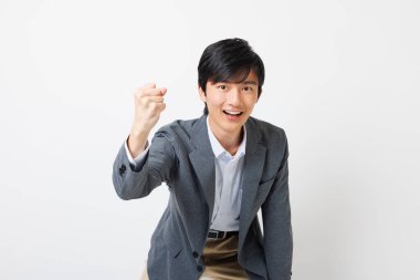 Ofisteki genç Japon adam beyaz arka planda tezahürat yapıyor.