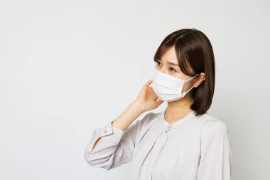 Beyaz arka planda maske takan güzel bir kadının portresi.