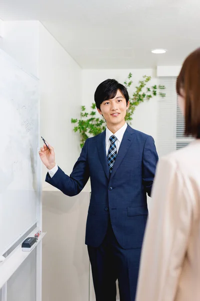 彼の同僚に提示するオフィス服の若い日本人男性 — ストック写真