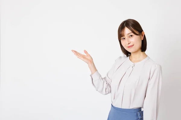 Ofisteki Genç Japon Kadın Beyaz Arka Planda Bir Şey Gösteriyor — Stok fotoğraf