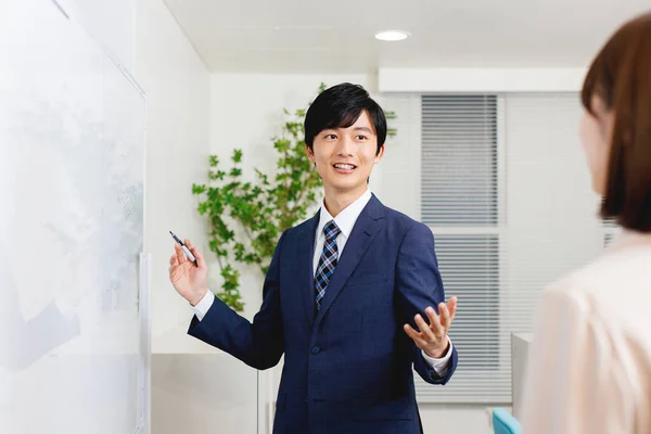 Молодий Японський Чоловік Офісному Вбранні Представляє Бізнес План Своєї Колеги — стокове фото