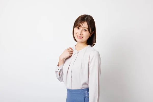 在办公室里的年轻日本女人穿着衣服站在镜头前微笑 — 图库照片
